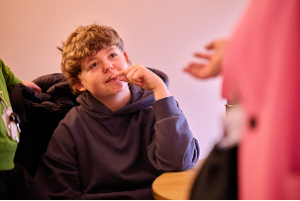 A young pupil looks up at the teacher, listening with curiosity