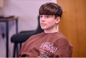 A schoolboy sits in the classroom, looking ahead attentively